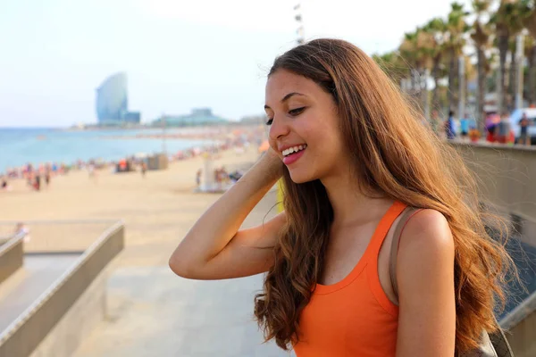 Beautiful happy city woman going at Barceloneta beach. Smiling young woman going to famous beach in Barcelona, Spain. Lifestyle concept.