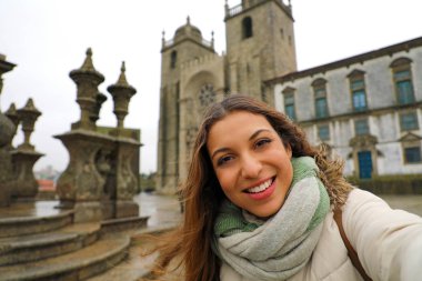 Mutlu genç kadın, kış döneminde Porto katedral önünde selfie fotoğraf al. Porto, Portekiz güzel kızın kendi kendine portre.