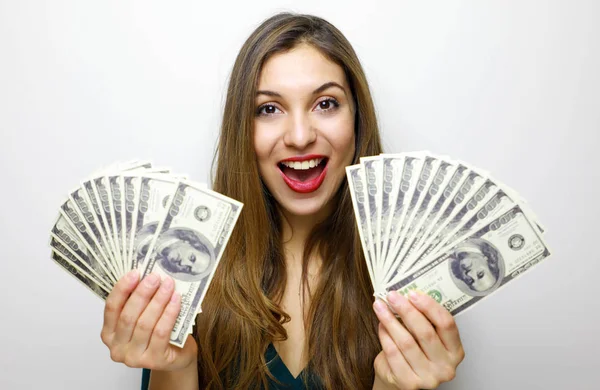Portrait of a happy young woman holding bunch of money banknotes isolated over white background