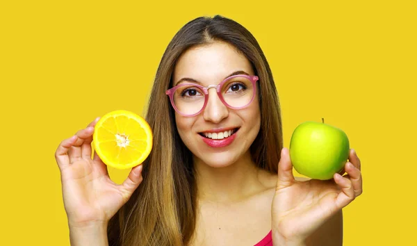 Gelukkig lachende vrouw met half oranje en groene appel op een yel — Stockfoto