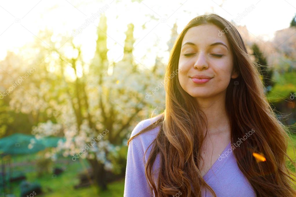 Woman smiling with closed eyes taking deep breath celebrating fr