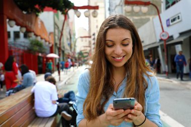 Sao Paulo City'de yürüyen gülümseyen genç bir kadının portresi 