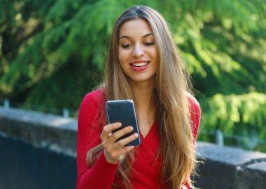 Kız yürüyüş ve sokakta bir akıllı telefon kullanarak