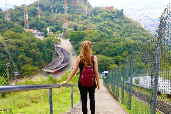 Ung turist flicka som bär ryggsäck fallande trappor och njuta av utsikten från Jaragua Peak, Brasilien — Stockfoto
