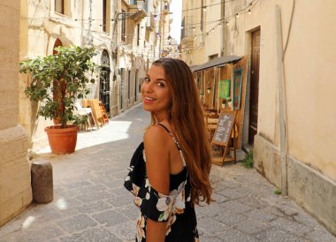 Mutlu gülümseyen güzel kadın çiçekli yazlık elbise Syracuse, İtalya neşeli ve neşeli yürüyüş. Sicilya Pretty seksi tabaklanmış model kız.