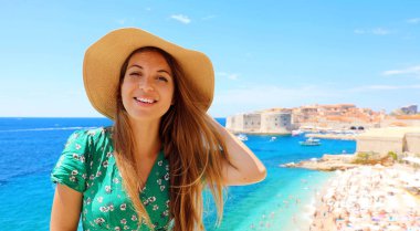 Hırvatistan'da şapkalı gülümseyen gezgin kız. Akdeniz'de Dubrovnik eski şehir ziyaret Mutlu genç kadın.