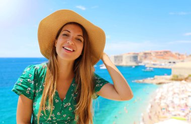 Hırvatistan'da şapkalı gülümseyen gezgin kız. Akdeniz'de Dubrovnik eski şehir ziyaret Mutlu genç kadın.