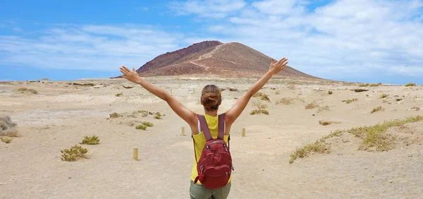 I arrived! Panoramic banner view of young hiking woman celebrating with raised arms the achievement of her goal.