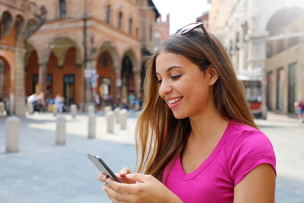 Retrato de una mujer sonriente usando un teléfono inteligente en la vieja ciudad medieval —  Fotos de Stock