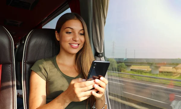 Mujer joven usando su teléfono inteligente en la vista de la pancarta del autobús — Foto de Stock