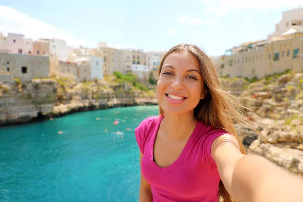 Mujer joven tomar selfie en sus vacaciones de verano en Polignano una yegua, Mar Mediterráneo, Apulia, Italia — Foto de Stock