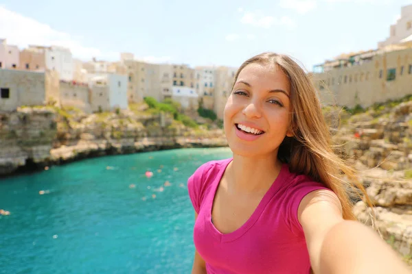 Mujer sonriente tomar autorretrato en sus vacaciones de verano en Polignano una yegua, Mar Mediterráneo, Italia — Foto de Stock