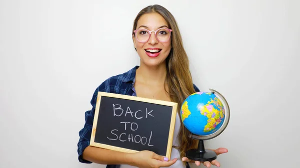 Beautiful young female student holding globe and blackboard with written back to school. — Stock Photo, Image