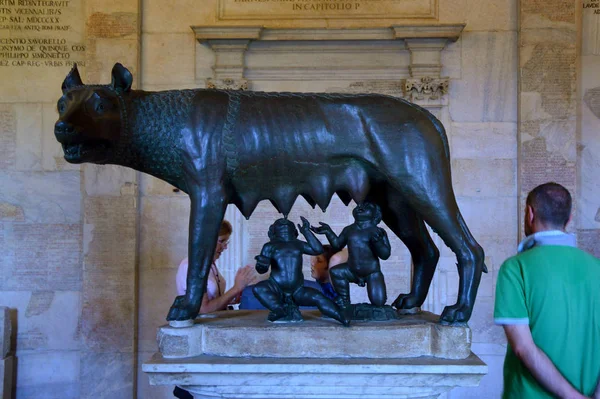 Řím, Itálie-6. dubna 2016: bronzová socha Capitolinského vlka (štěňata Capitolina) v Capitolinském muzeu s turisty. Vlčice krmí malé Romulus a Remus. — Stock fotografie