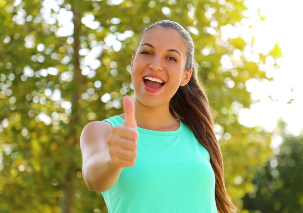 Super mulher! Retrato da rapariga vencedora a mostrar o polegar. Sorrindo positivo fitness mulher saudável ao ar livre . — Fotografia de Stock