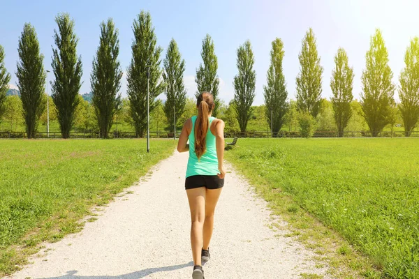 Młoda sportowa kobieta działa w parku. Fitness dziewczyna jogging w parku. Widok z tyłu sportowy dziewczyna działa na szlaku. — Zdjęcie stockowe