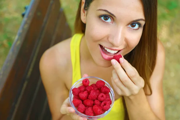 Крупним планом красива сексуальна жінка їсть ягоди в парку . — стокове фото