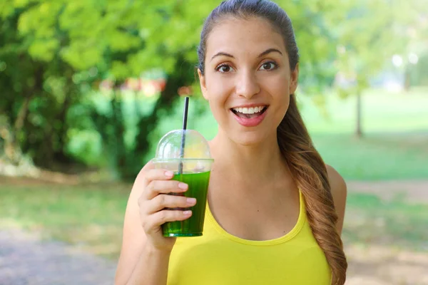 Jeune belle femme sportive boire smoothie vert de désintoxication. Fitness girl boire smoothie aux légumes après l'entraînement de course de fitness le jour d'été . — Photo