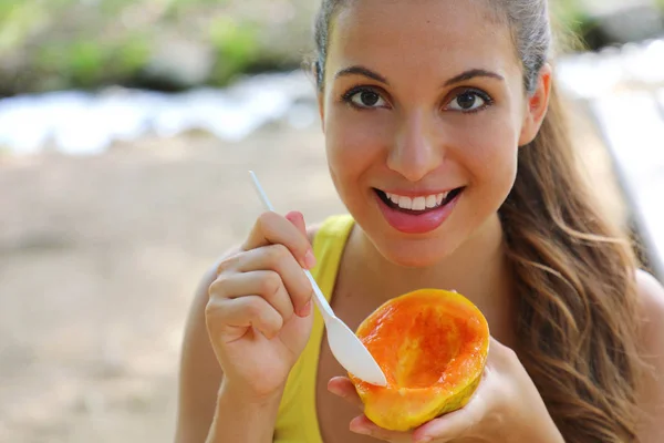 Aantrekkelijke Braziliaanse vrouw het eten van een Papaya fruit buiten. — Stockfoto
