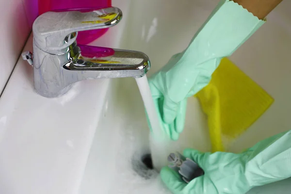 Mãos femininas limpando torneira de água no banheiro . — Fotografia de Stock