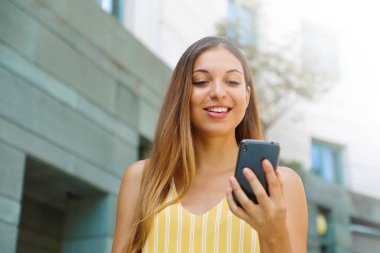 Mutlu başarılı iş kadını sokakta telefon kontrol.
