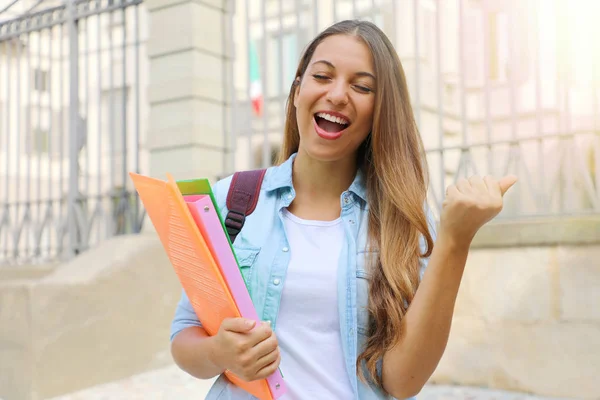 Happy student girl doing student exchange programme in Italy. Excited Young woman raising fist up outdoor. — Stock Photo, Image