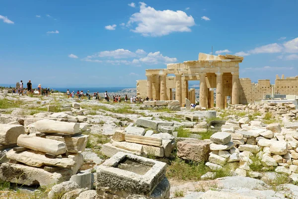 Ruinas griegas en la Acrópolis, Atenas, Grecia. Personas no identificadas caminando por Propylaea en la Acrópolis en un día soleado . — Foto de Stock