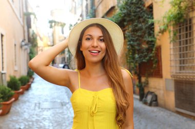 Trastevere, Roma'da çekici bir kız. Sarı elbise ve şapka ile güzel moda kadın Roma sokaklarında yürür, İtalya.