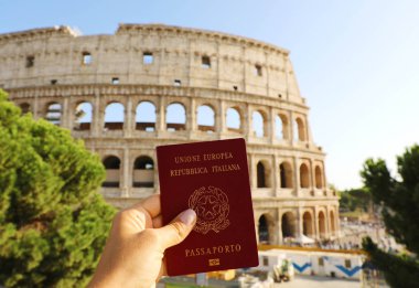 Vatandaşlık kavramı: el Roma'da Colosseum önünde İtalyan pasaportu tutun.
