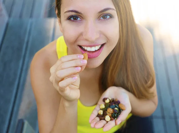 Fitness mulher saudável comer mistura de sementes de nozes frutas secas ao ar livre . — Fotografia de Stock