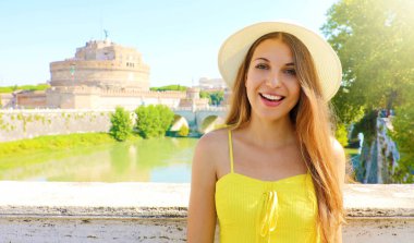 İtalya 'da tatiller. Roma, İtalya 'da gülümseyen güzel bir turist kız. Arkasında Castel Sant Angelo kalesi olan çekici bir moda kadını..