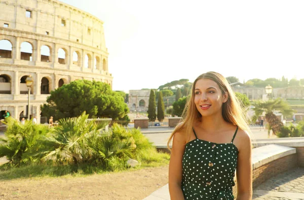 Portret van een lachend mooi meisje in Rome met Colosseum op de achtergrond bij zonsondergang. Zomervakantie in Italië. — Stockfoto