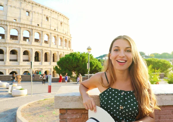Gelukkig glimlachend mooi toeristisch meisje in Rome met Colosseum op de achtergrond bij zonsondergang. Zomervakantie in Italië. — Stockfoto