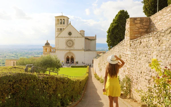Turismo in Italia. Veduta posteriore della bella ragazza che cammina verso la Basilica di San Francesco d'Assisi in Umbria . — Foto Stock