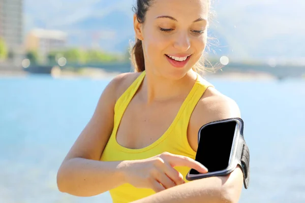 Corredor atleta escuchando música de teléfono inteligente reproductor de mp3 brazalete de teléfono inteligente. Mujer fitness jogging entrenamiento bienestar concepto . — Foto de Stock