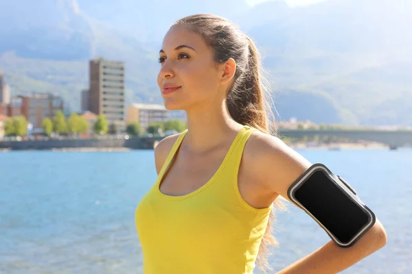 Atleta femenina positiva exitosa que usa brazalete en blanco para hacer publicidad antes de correr o hacer ejercicio al aire libre en verano. Éxito de la mujer en el deporte . — Foto de Stock