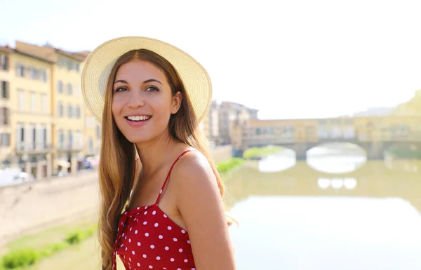 Menina sorridente feliz em Florença com Ponte Vecchio ponte e Arno rio no fundo. Retrato de uma jovem mulher visitando a beleza da Toscana na Itália . — Fotografia de Stock
