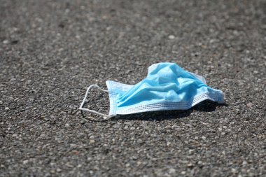 Çevre kirliliği. Asfalta kullanılmış cerrahi maske takın. Sokakta tek kullanımlık yüz maskesi.