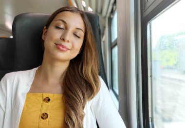 Yorgun iş kadını bir gün çalıştıktan sonra trende uyuyor. Tren yolcusu rahat rahat uyuyor..