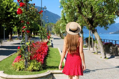 İtalya, Bellagio 'nun çiçekli caddesinde Como Gölü' nde yürüyen büyüleyici bir kız.