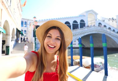 Venedikli turist kız yazın ünlü Rialto Köprüsü ile selfie çekiyor. İtalya 'da Venedik turistik merkezi.