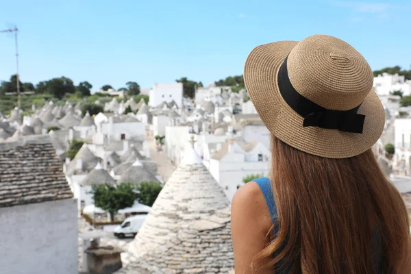 Güney İtalya 'daki geleneksel Trulli evleriyle Alberobello' yu ziyaret eden genç turist kız.