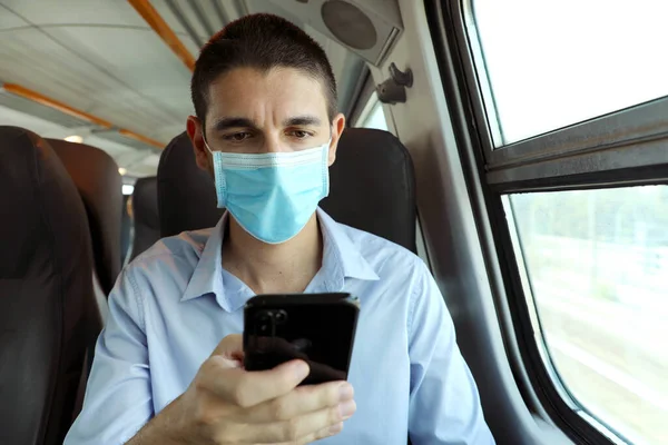 수송에 스마트폰 사용하는 마스크를 보호용 마스크를 착용하고 비즈니스 클래스에 앉아서 — 스톡 사진