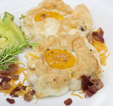 Yumurta ve peynir ve otlar beyaz bir plaka üzerinde avokado bulut