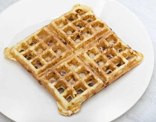 Homemade square belgian waffle on white plate
