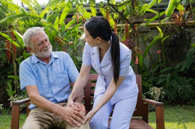 kıdemli adam mutluluk gülümseyen hemşire ile oturan, k dikkat ediyor