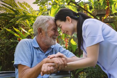 kıdemli adam mutluluk gülümseyen hemşire ile tekerlekli sandalyede oturan, t