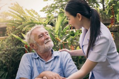 kıdemli adam mutluluk gülümseyen hemşire ile tekerlekli sandalyede oturan, t