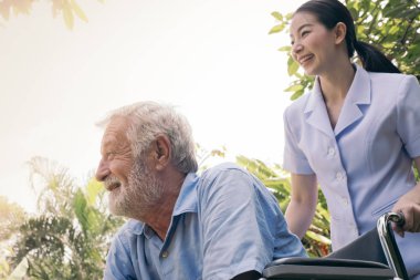 tekerlekli sandalyede oturan ve smil ile bakarak kıdemli adam mutluluk