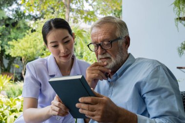 gülümseyen hemşire ile kıdemli adam mutluluk, b birlikte kitap okuyun